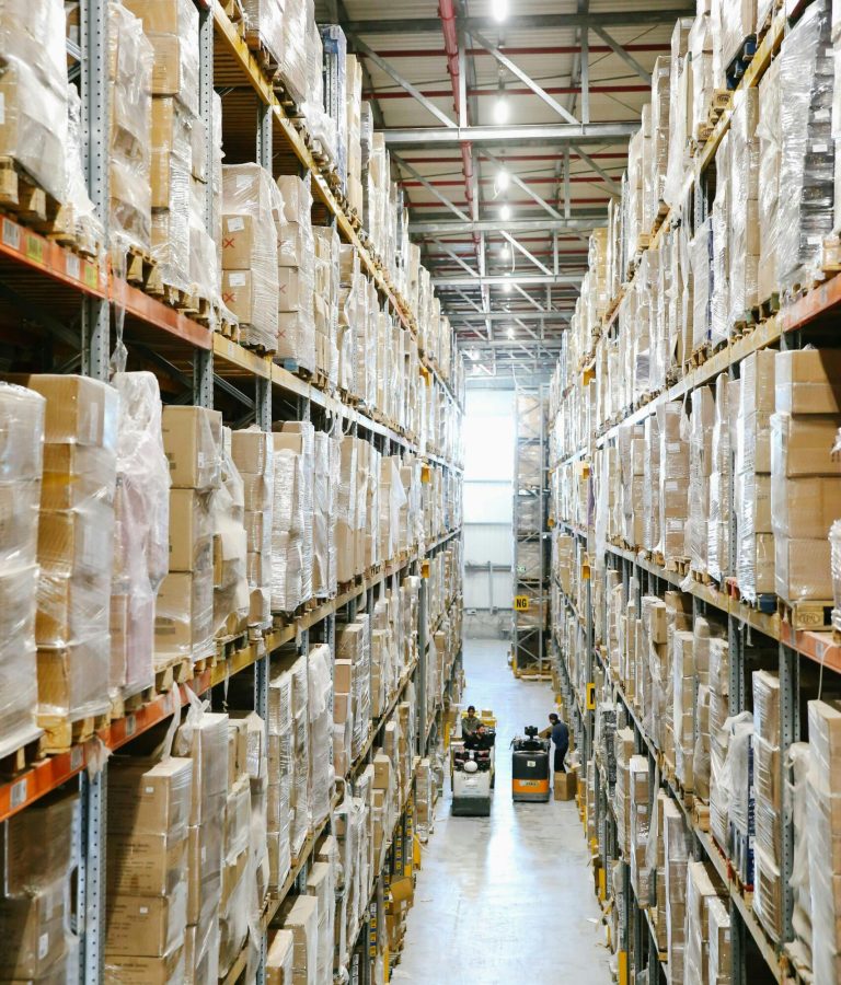 Spacious warehouse aisles lined with shelves stacked with boxes and packaging.